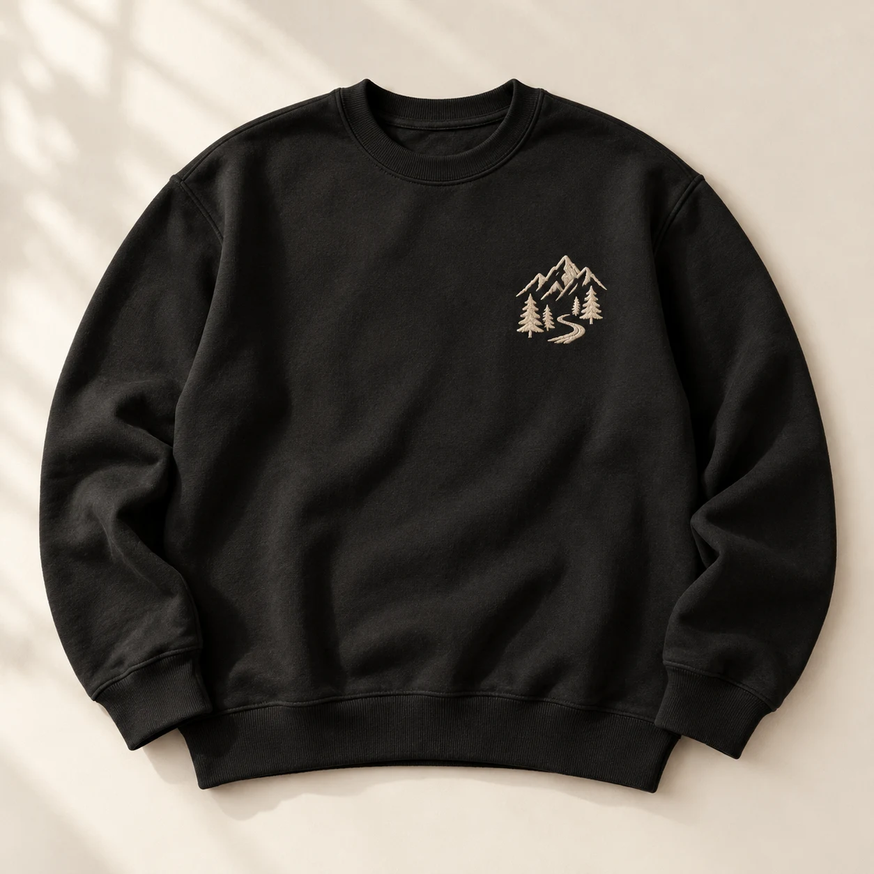 Studio concept: a dark sweatshirt with a mountain embroidery design